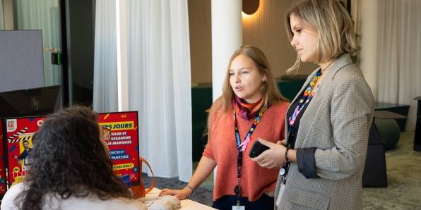 Deux collaboratrices dans leur bureau au siège social, regardant une magazine LIDL