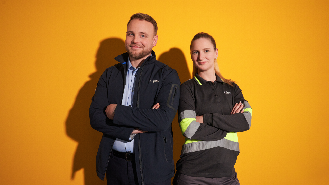 Jeune homme travaillant en supermarché et jeune femme en logistique, côte à côté et complices