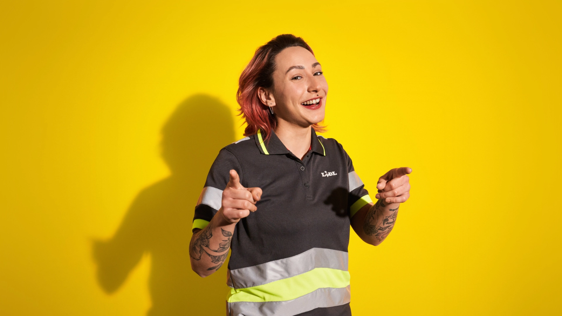 Portrait d'une Jeune femme en tenue logistique qui regarde la caméra d'un oeil complice