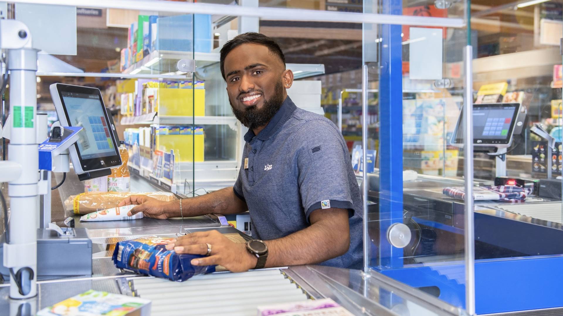 Jeune homme passant des articles en caisse