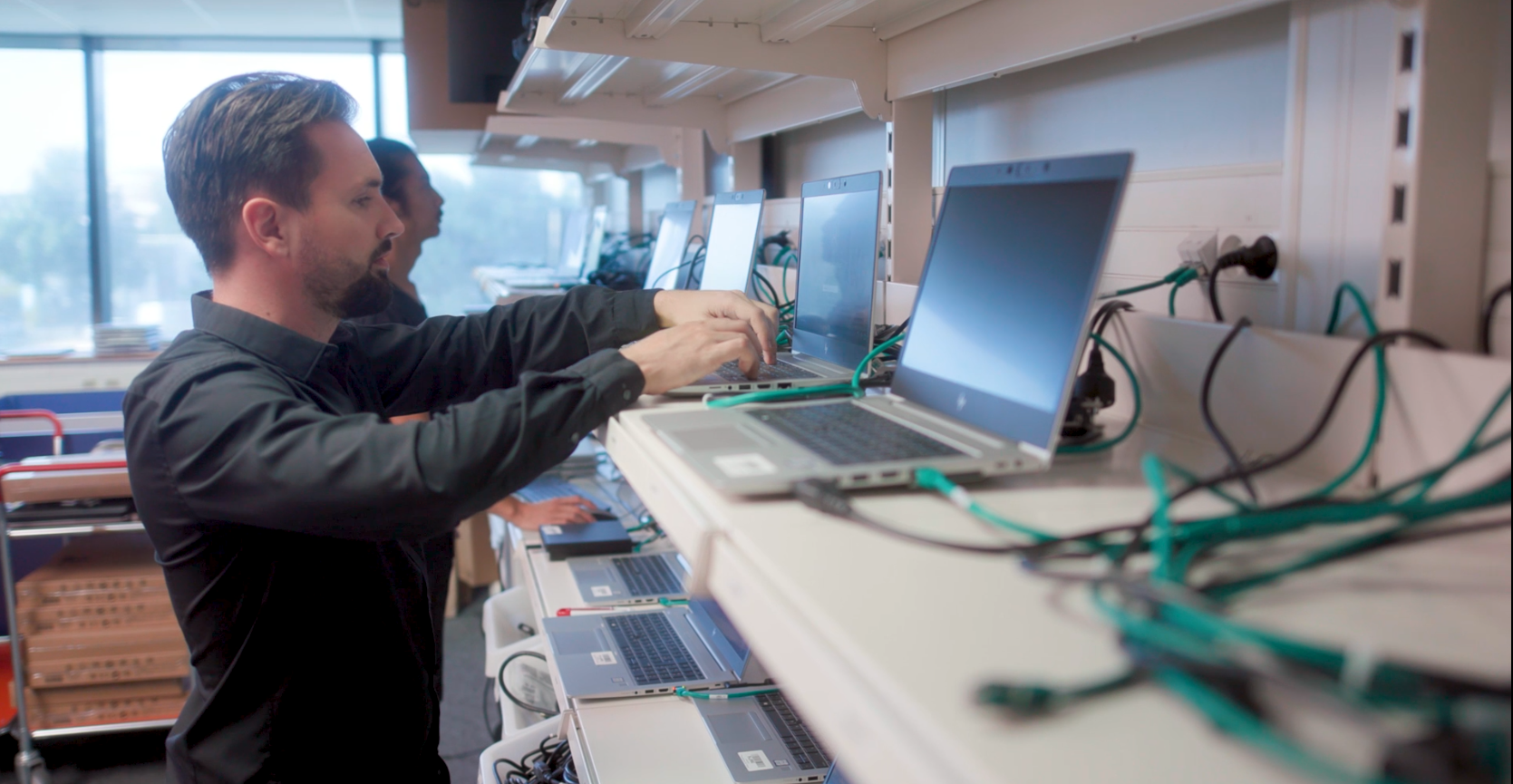Deux membres de l'équipe informatique dans leur bureau en train de travailler avec concentration