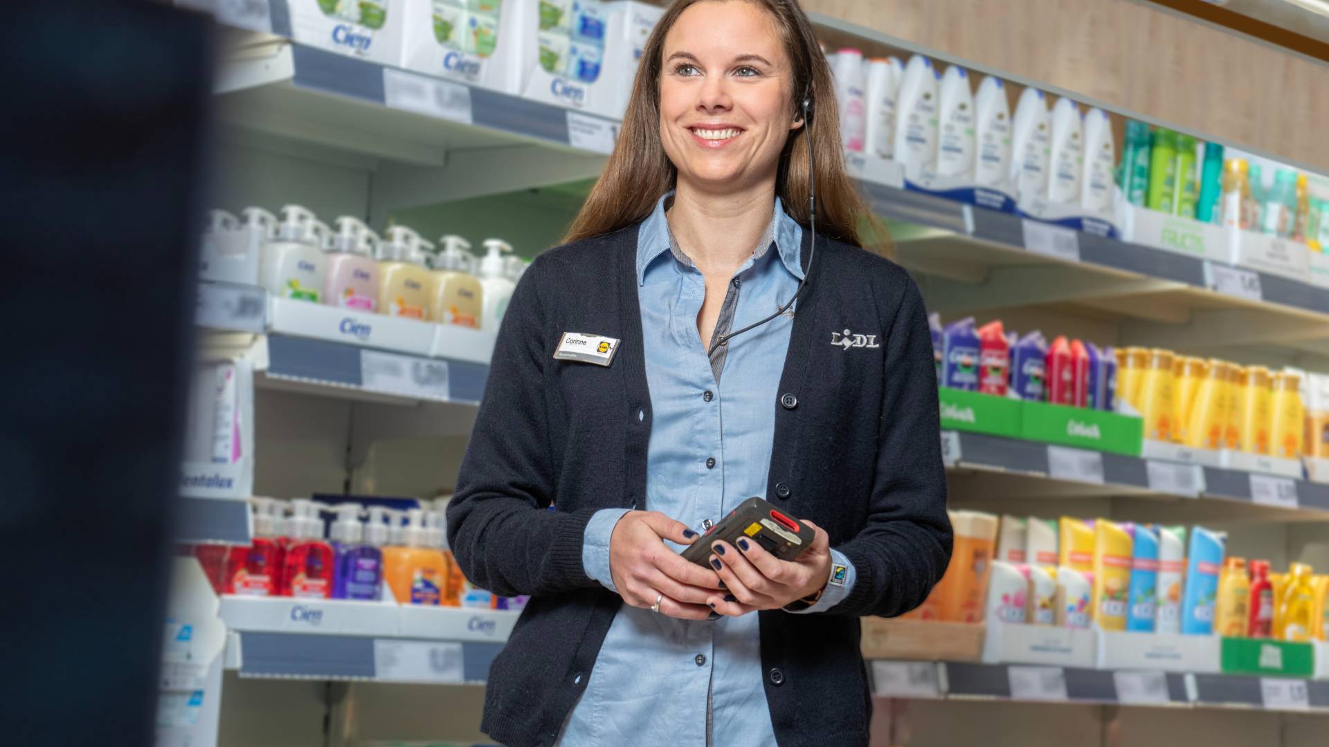 Une femme directrice de supermarché souris après avoir finit de scanner des produits en rayon
