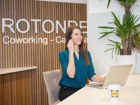 Jeune collaboratrice au téléphone dans un espace de coworking partagé au sein du siège de Strasbourg