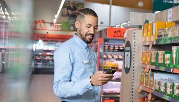 Manager homme vérifiant les produits au rayon Bio d'un supermarché Lidl