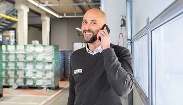 Manager au téléphone au milieu d'une plateforme logistique